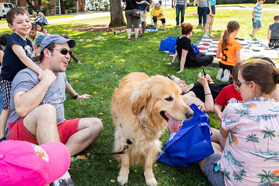 Parents with their children and a dog at Tufts community day